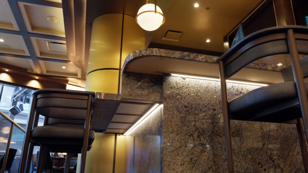 Close-up of a luxurious bar featuring a polished natural stone countertop and matching stone wall.