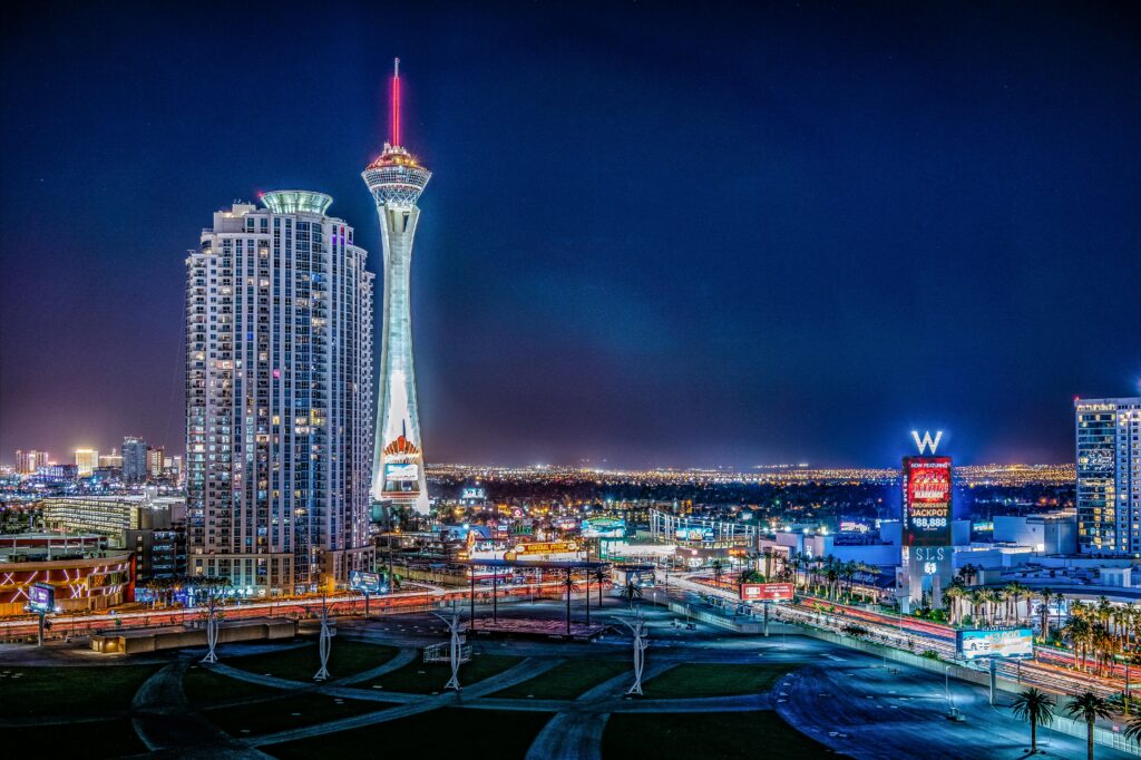 Night view of the iconic Stratosphere Tower and a hotel in the glittering Las Vegas cityscape.