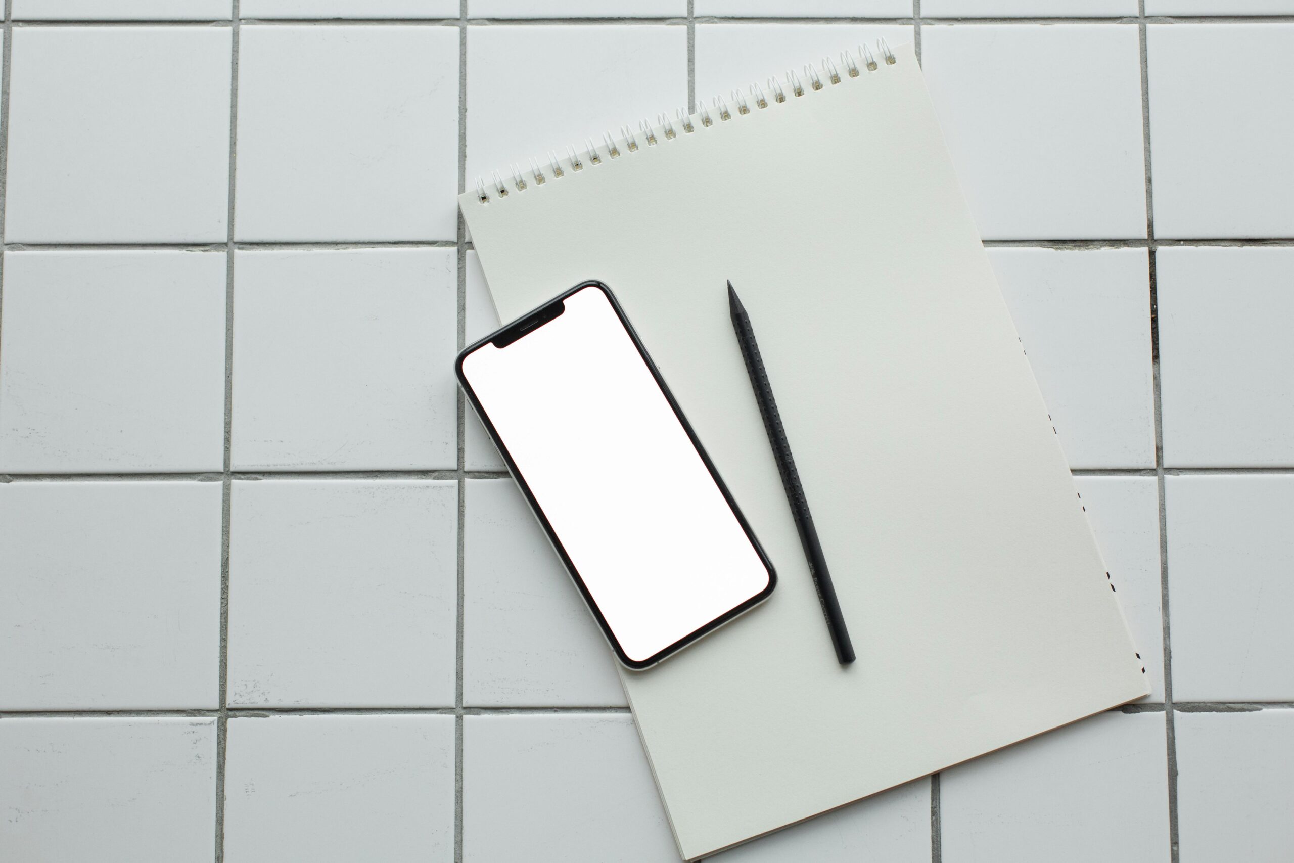 Overhead view of a light-colored grid-patterned tile surface.