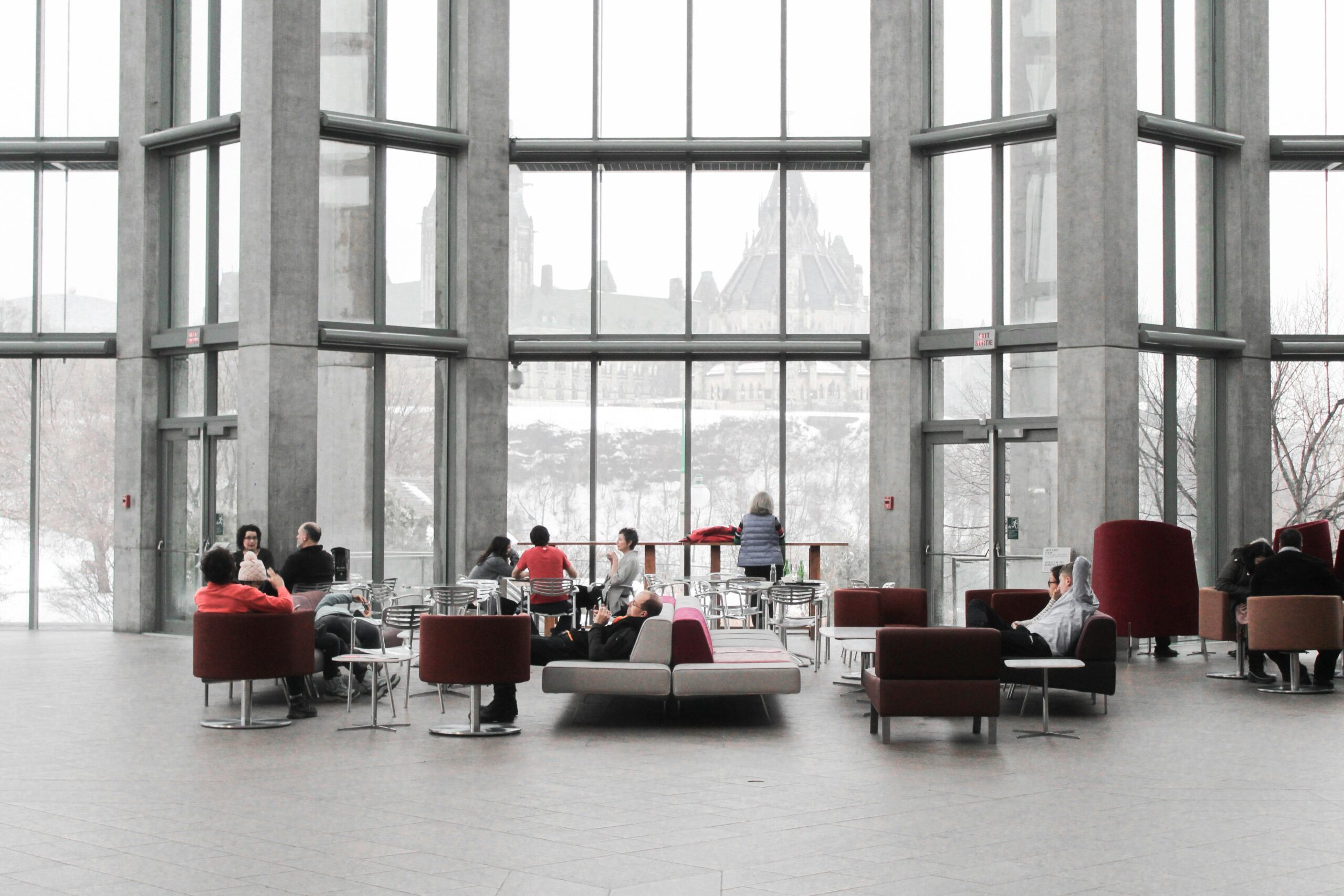 Spacious modern lobby with light-colored tile flooring and large windows framed with stone, reflecting a clean and open commercial space.
