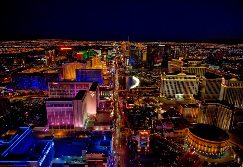 Aerial night view of the illuminated Las Vegas Strip, showcasing brightly lit hotels.