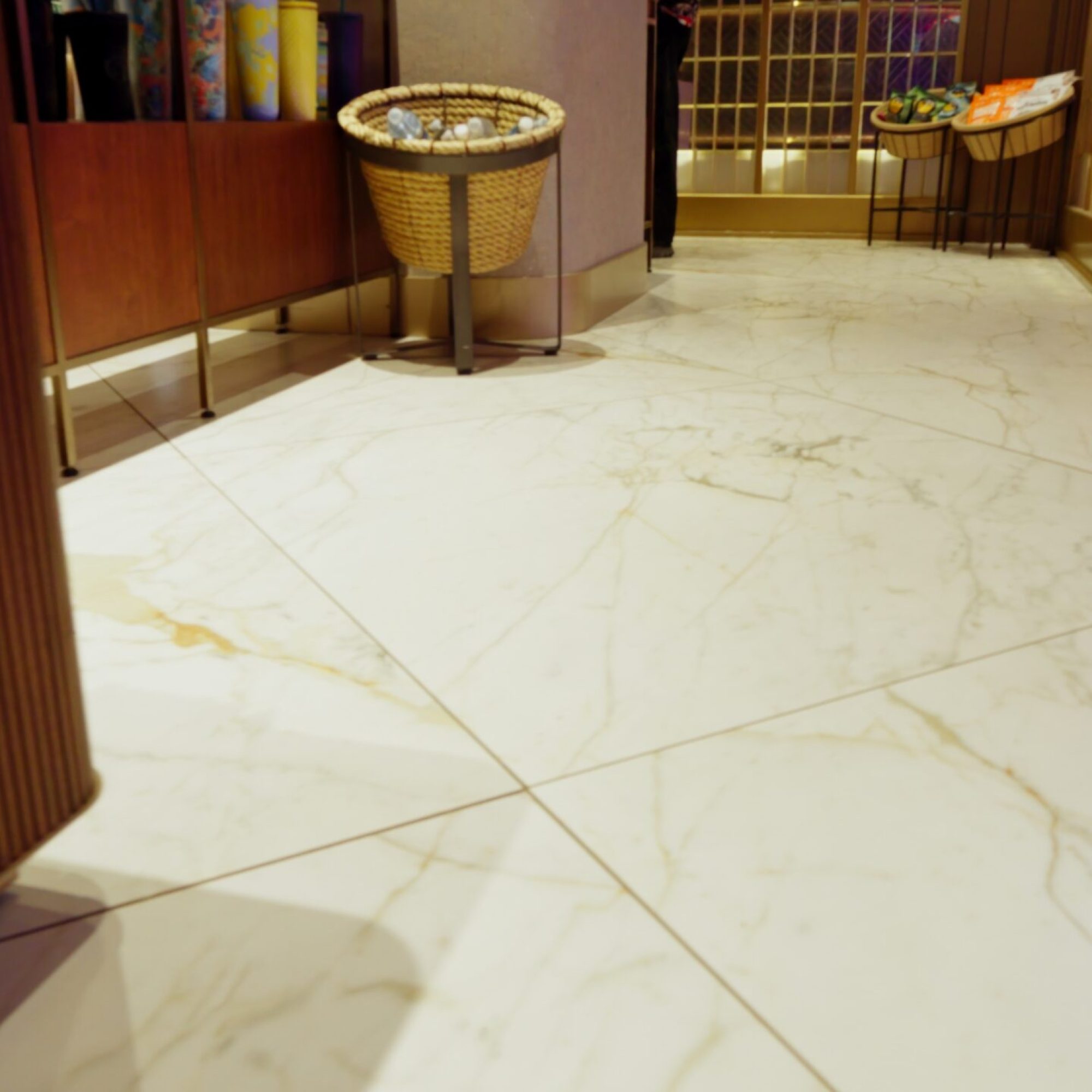 Polished white marble floor tiles with subtle golden veining, showcasing a high-quality stone flooring installation.